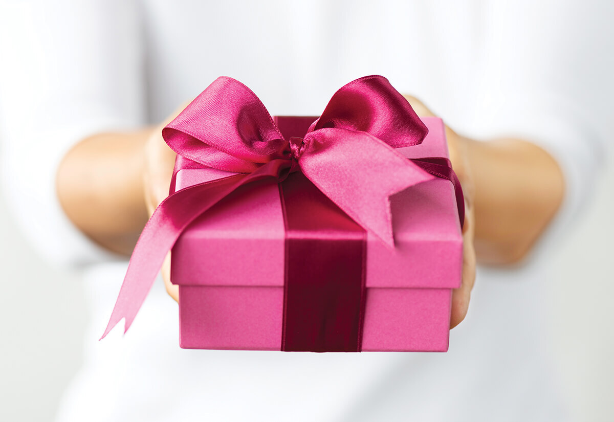 Image of someone holding a pink gift box